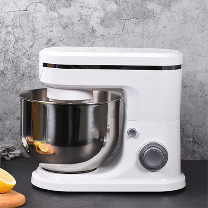 White stand mixer with a silver bowl on a gray surface.