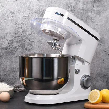 White stand mixer with a silver bowl on a gray surface with lemons and eggs.